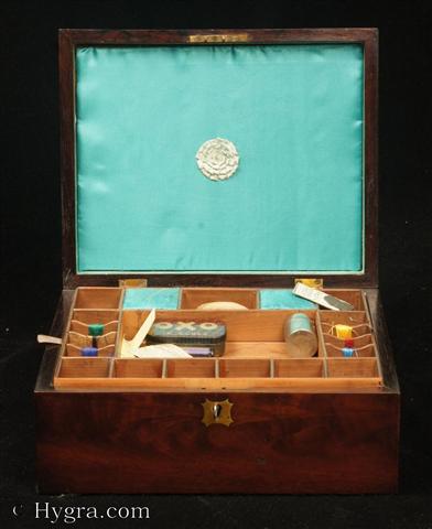 Antique flame mahogany sewing box with lift-out  compartmentalized tray fitted with silk winders and further spaces for thread reels. The tray is made from straight grained pine. The inside of the lid is lined with blue silk. There are brass escutcheons to the top and front. Circa 1830 Enlarge Picture